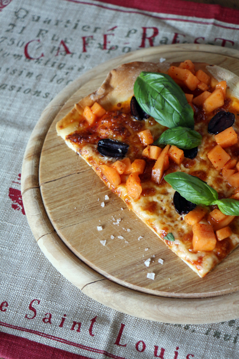 Pizza mit schwarzen Oliven, Basilikum und Melonen-Salsa